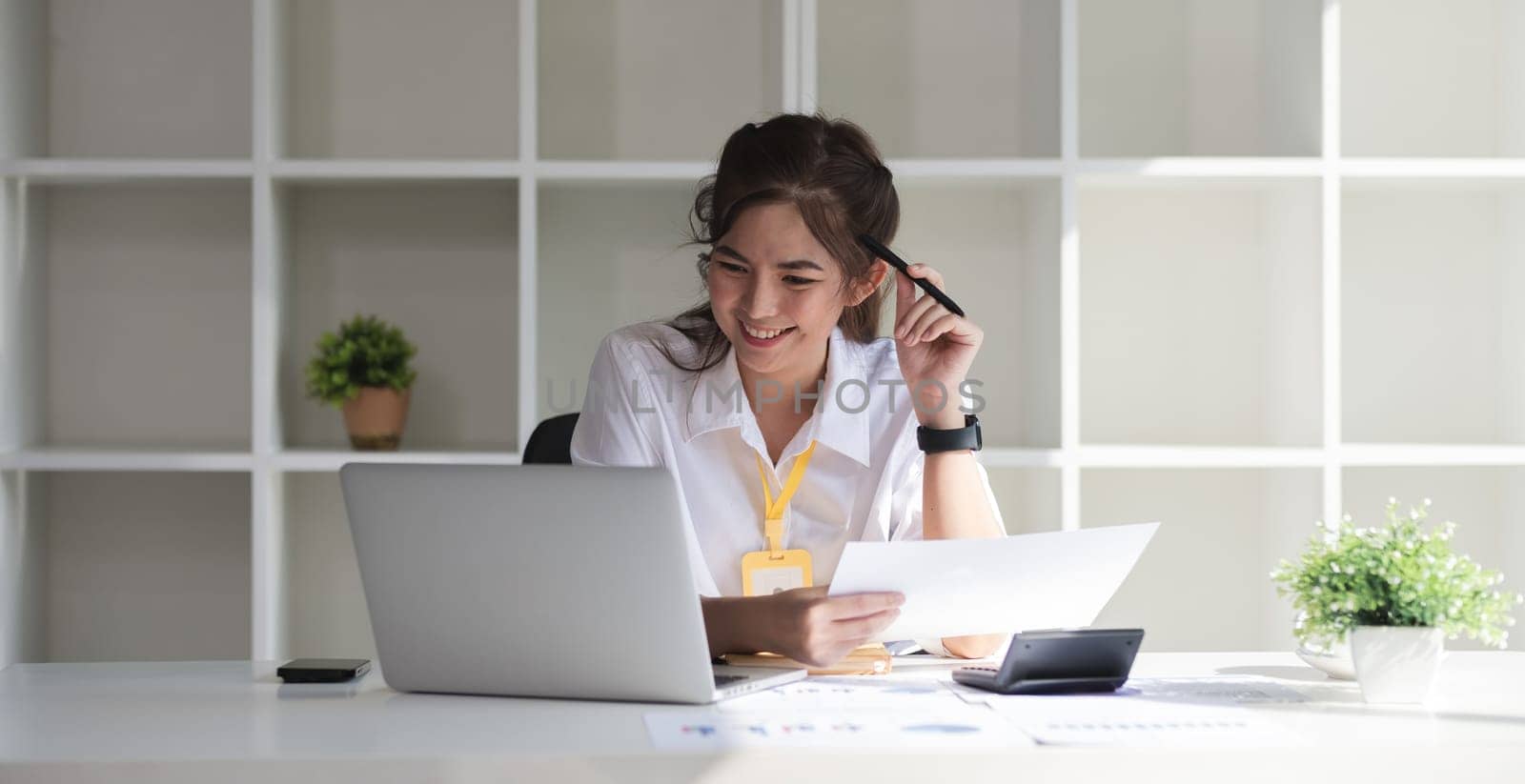 Business woman using calculator for do math finance on wooden desk in office and business working background, tax, accounting, statistics and analytic research concept. by wichayada