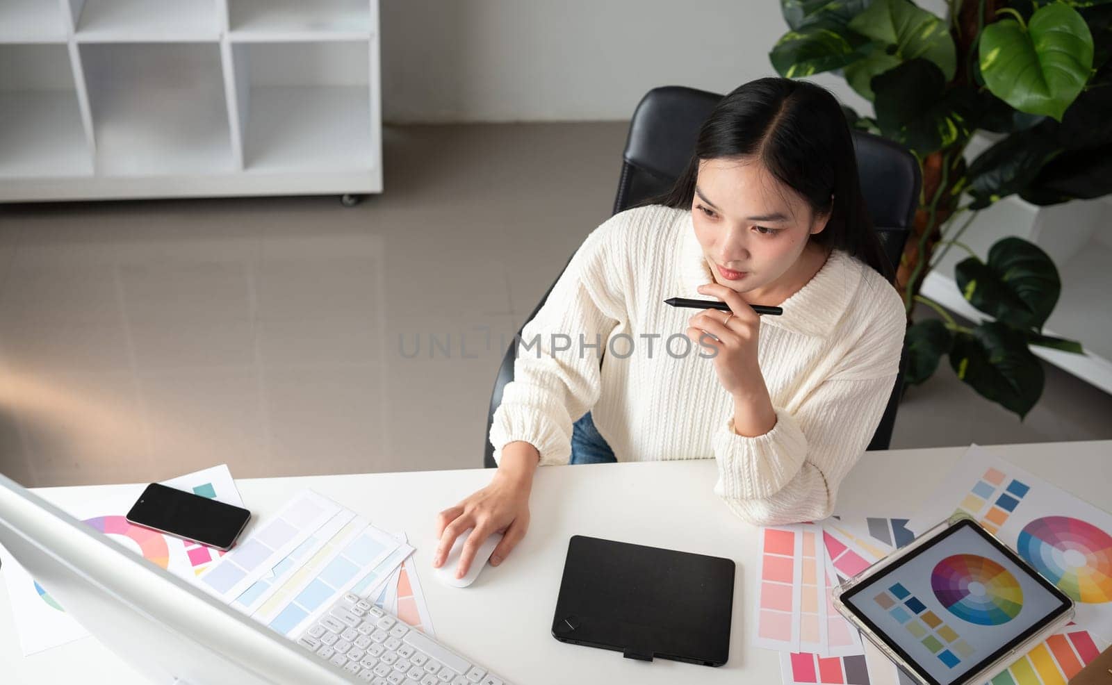 Top view of female designer working in graphic design using computer Sit and choose colors and work intently in your office..