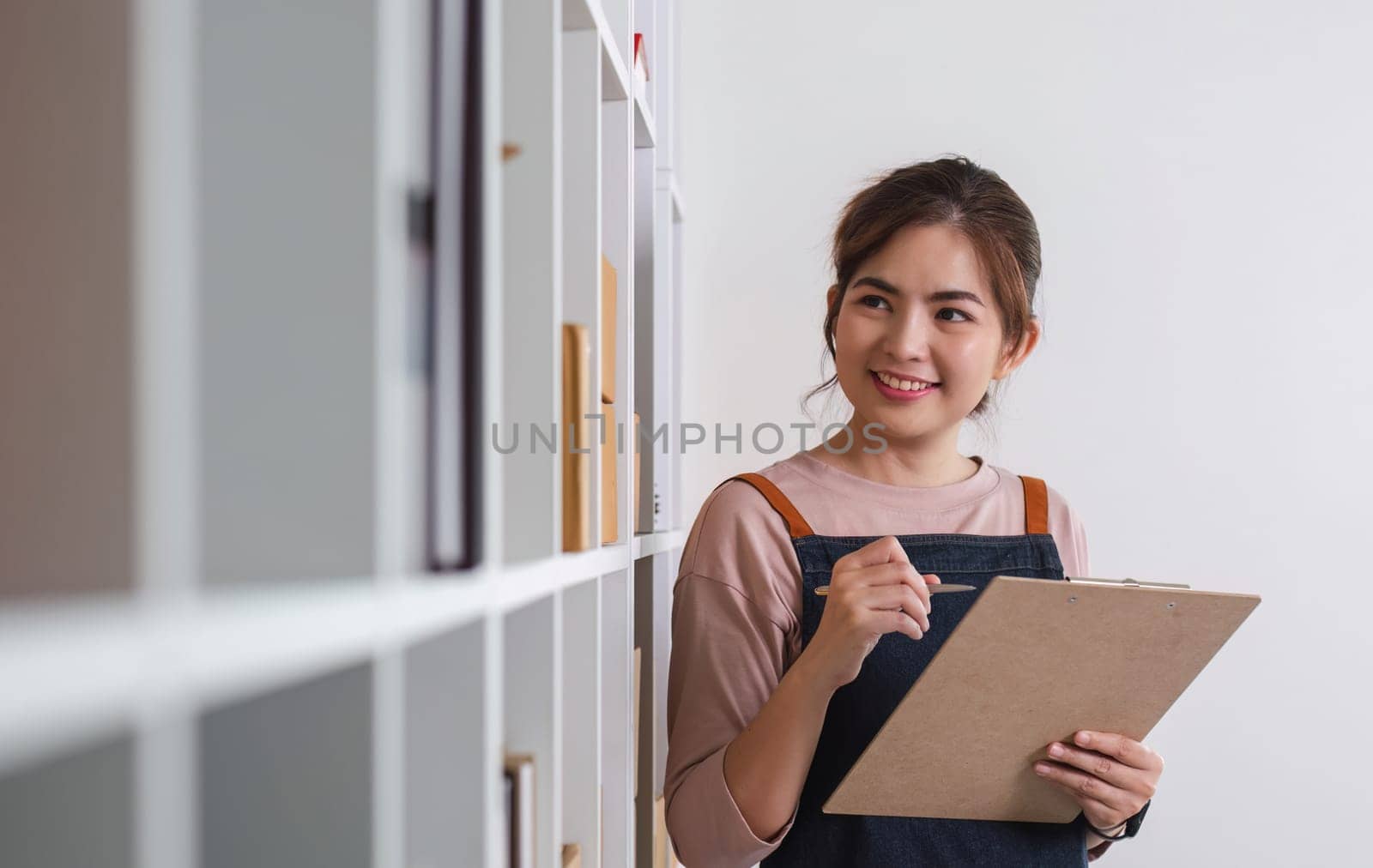 Female online business owner checks stock of products waiting to be delivered to customers. A talented SME business owner. by wichayada