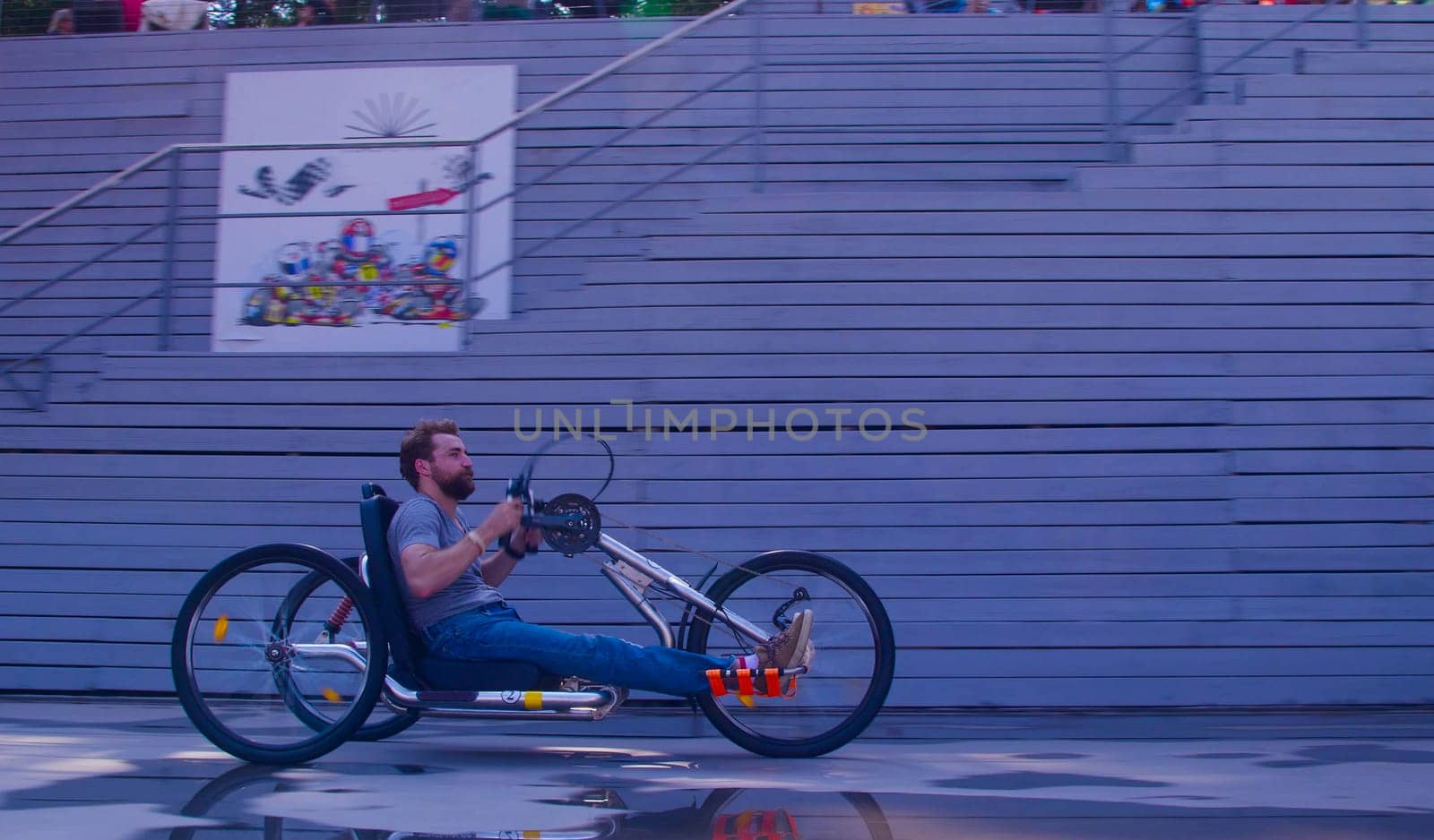 Happy young disable man is riding hand bike by Chudakov