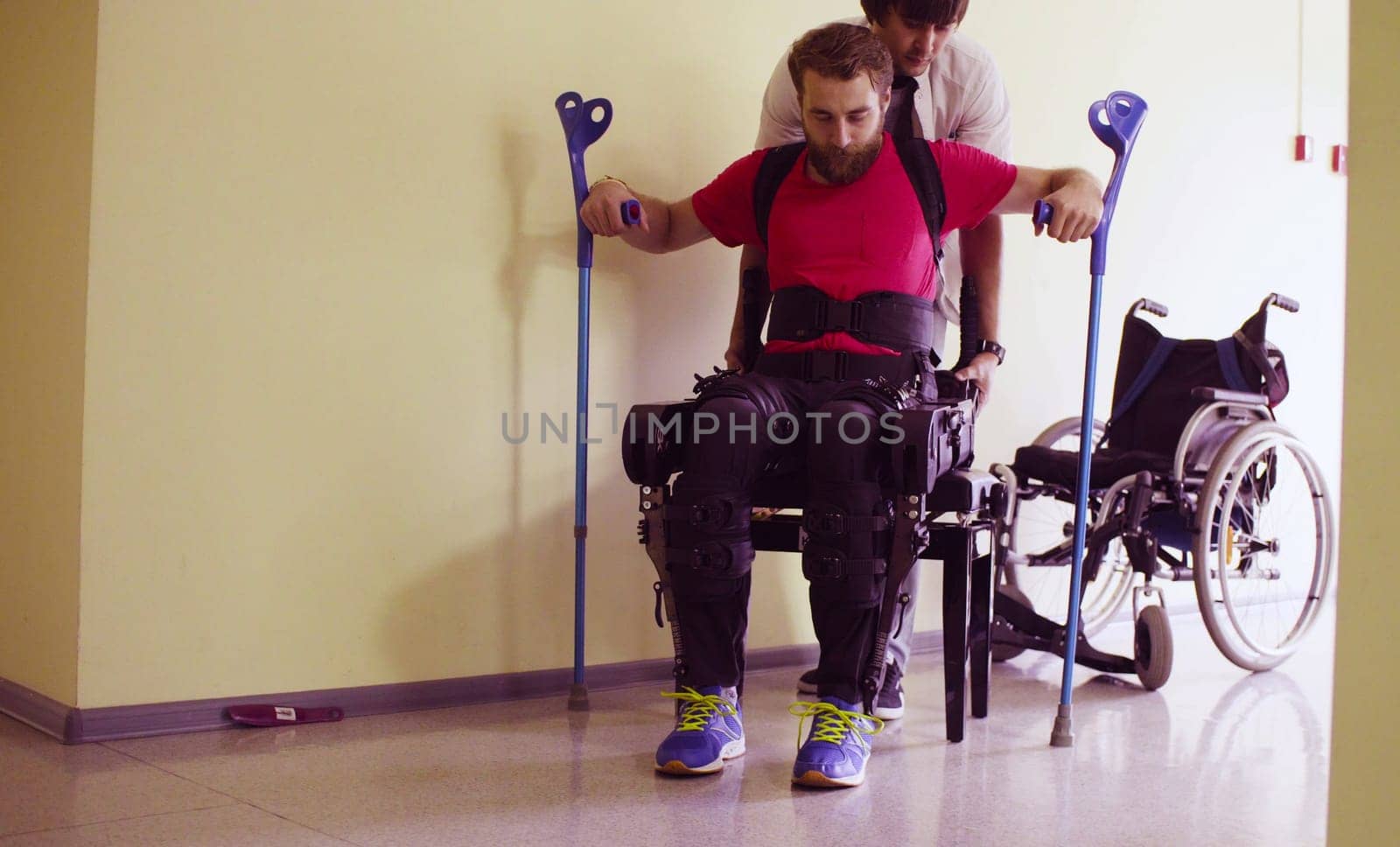 Young disable man in the robotic exoskeleton by Chudakov