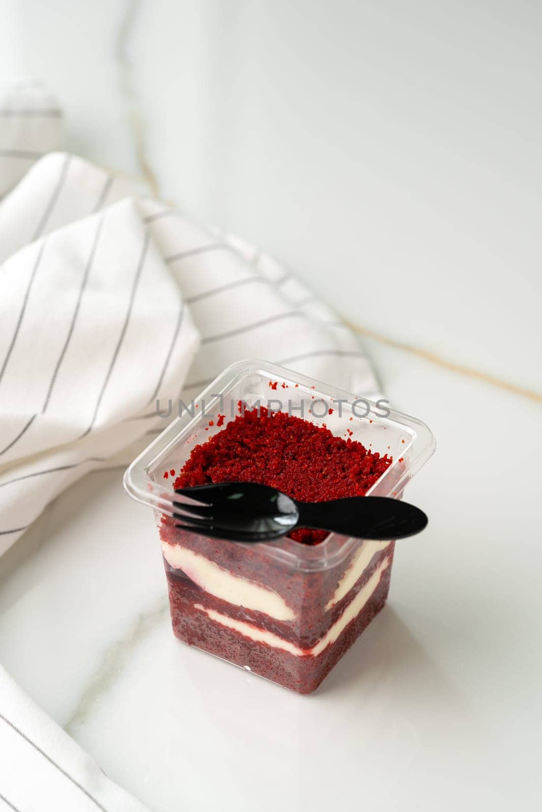 Trifle red velvet in plastic cup on table close up