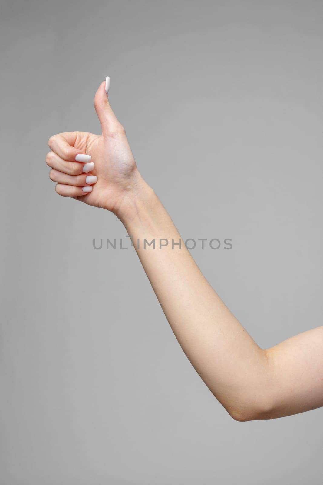 Female hand gesturing sign against gray background by Fabrikasimf