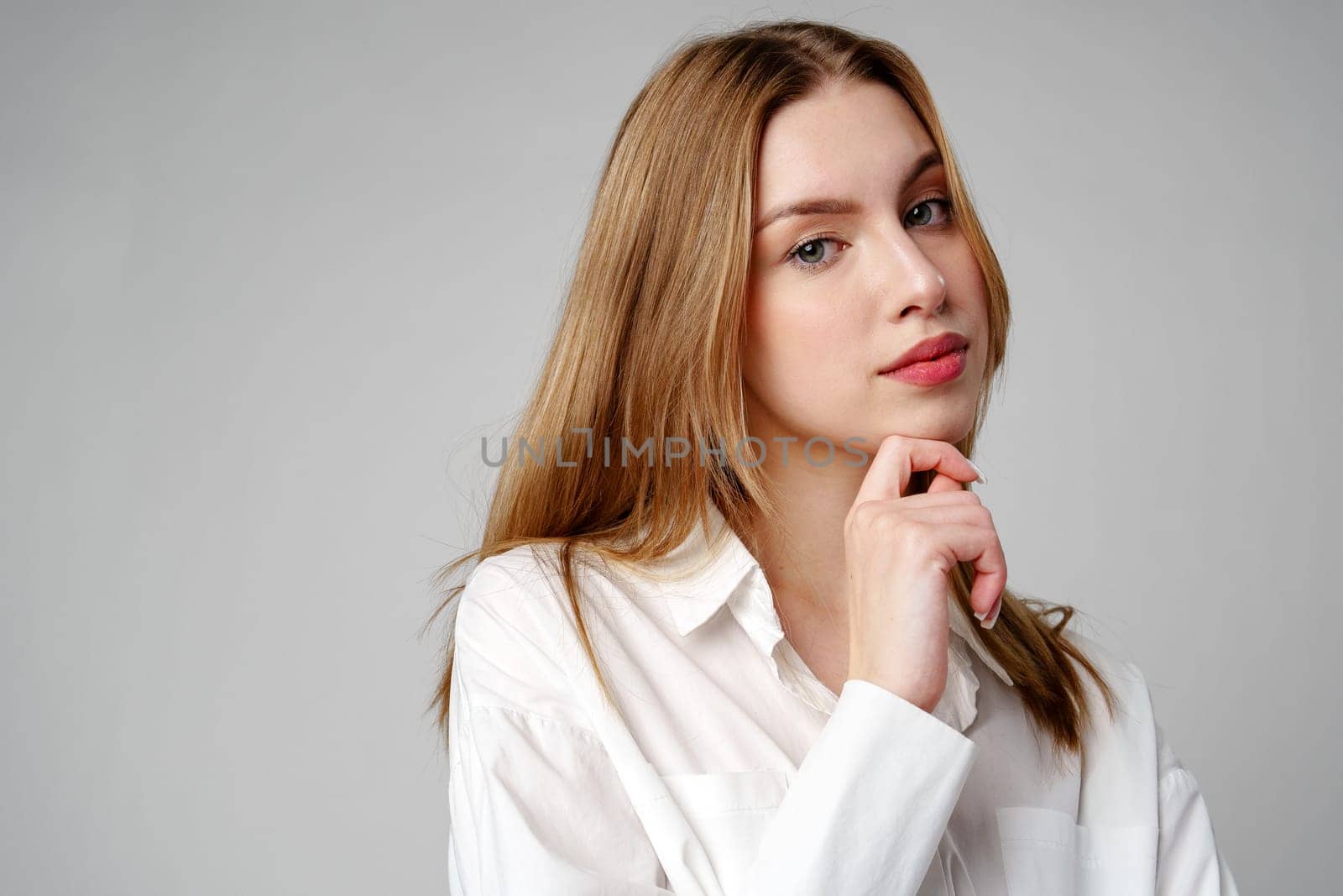 Concerned Young Woman deep in thought or contemplation on gray background