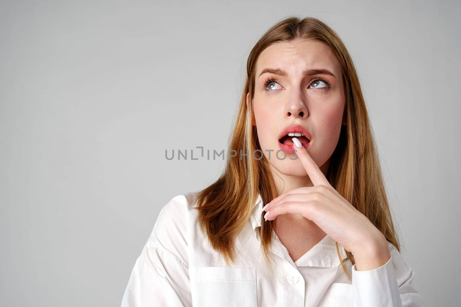 Woman in White Shirt Holding Finger to Lips by Fabrikasimf