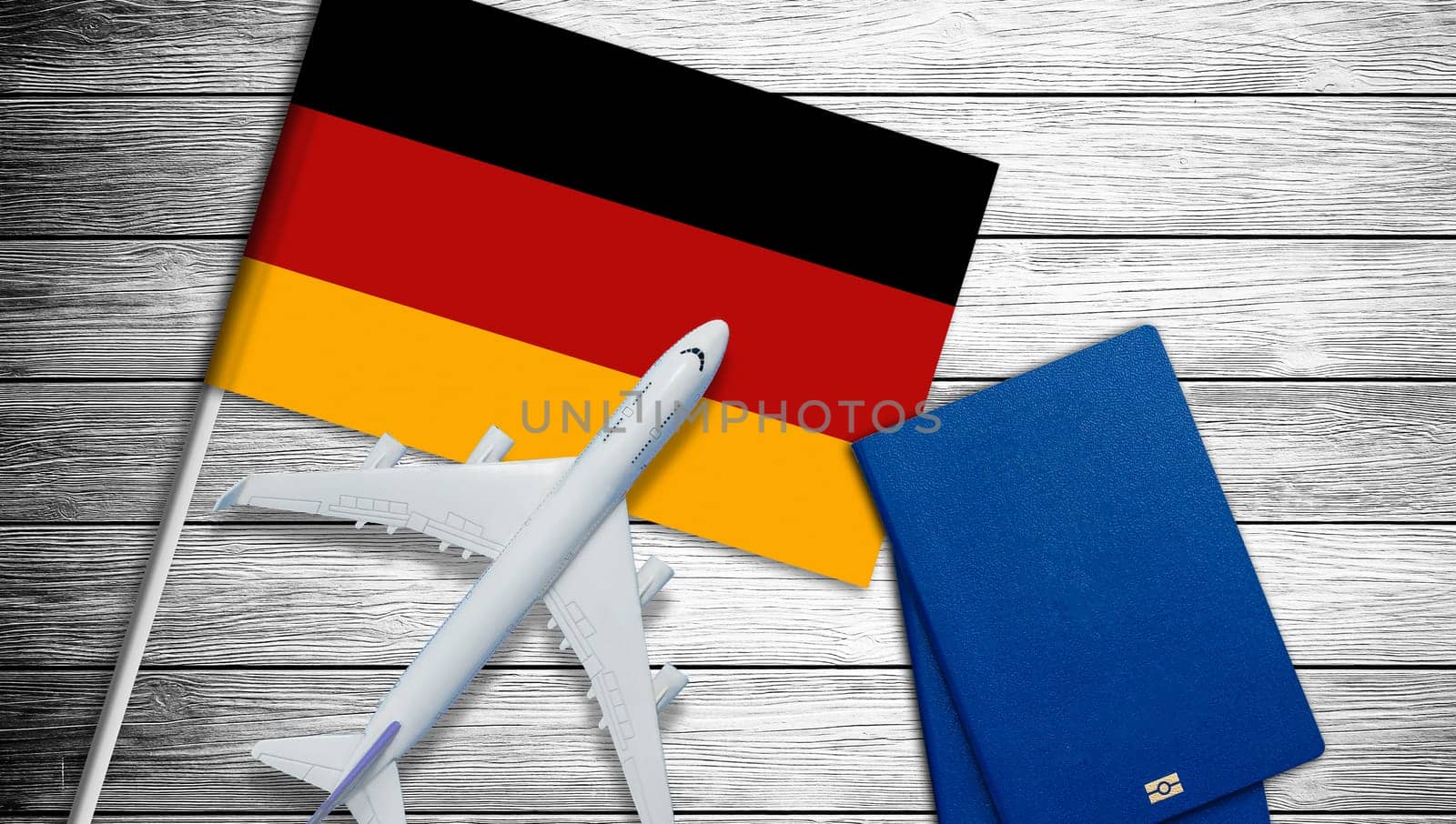 Flag of Germany with passport and toy airplane. Flight travel concept. by Andelov13