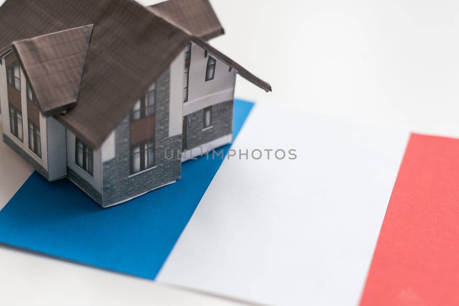 House model near France flag. Real estate sale and purchase concept. Space for text. High quality photo