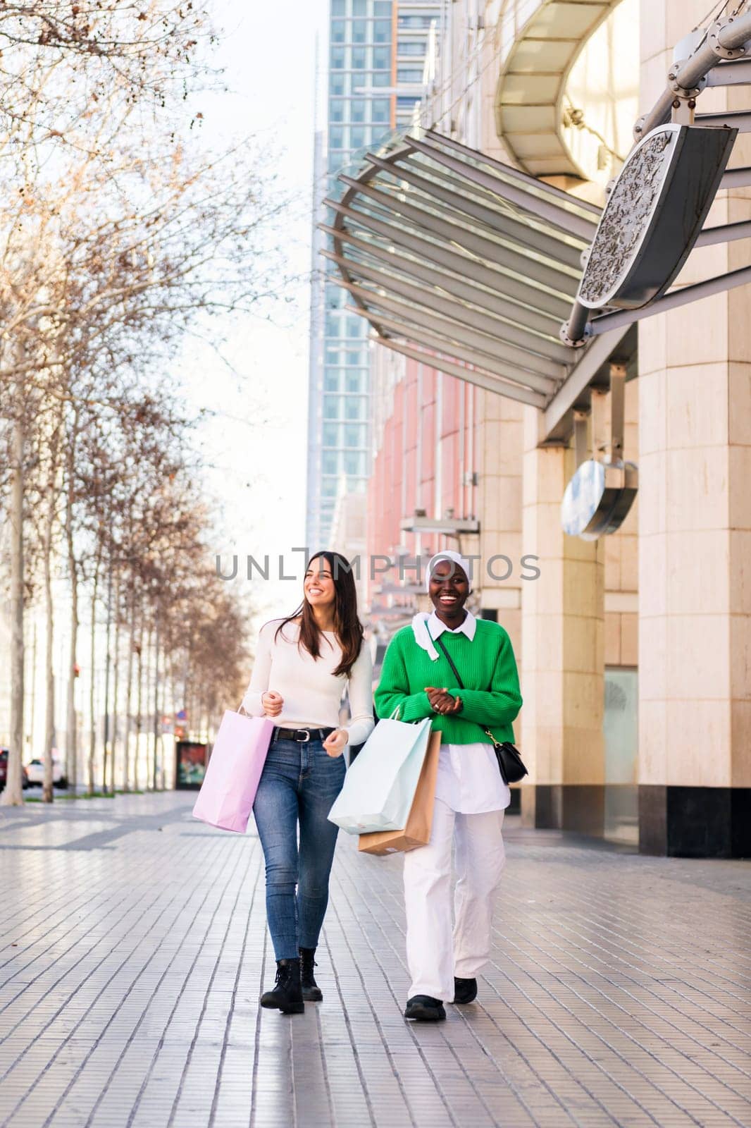 multiracial couple of female friends smiling happy walking in a shopping area, friendship and modern lifestyle concept, copy space for text