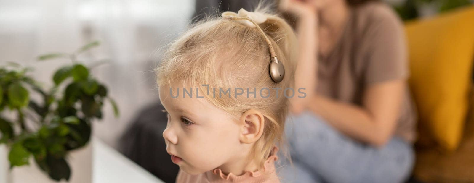 Banner Cochlear implant system copy space. Installation cochlear implant on child girl ear for restores hearing. Kid hears after hear return to normal by Satura86