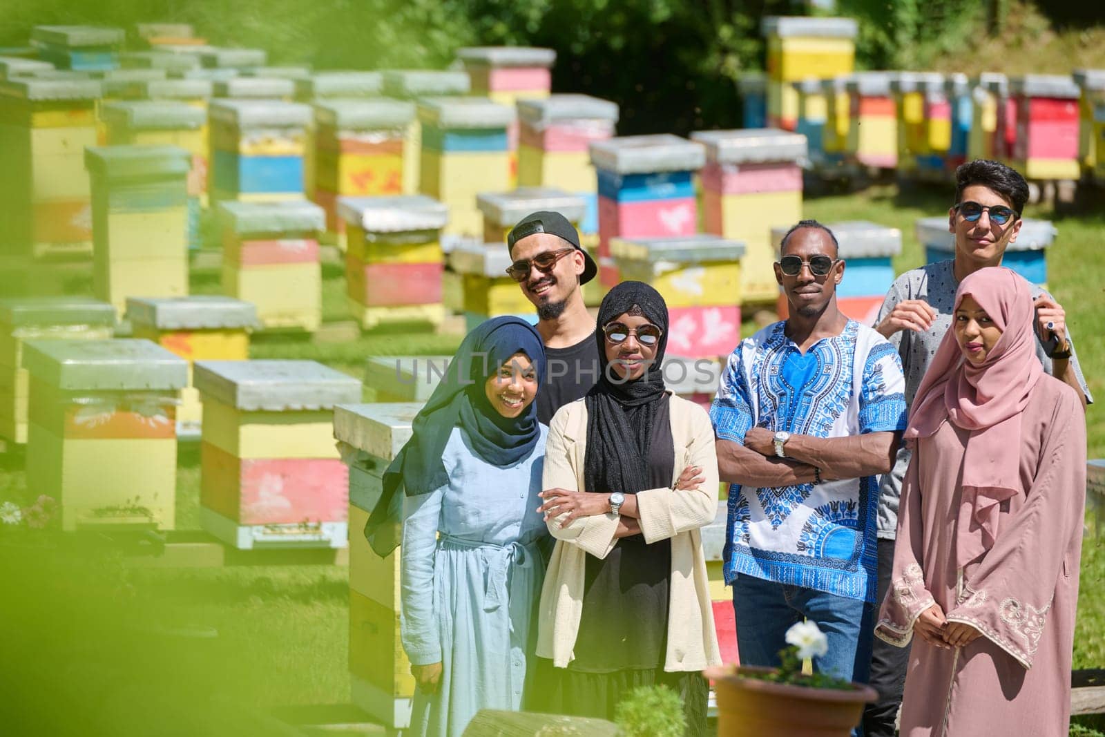 A diverse group of young friends and entrepreneurs explore small honey production businesses in the natural setting of the countryside