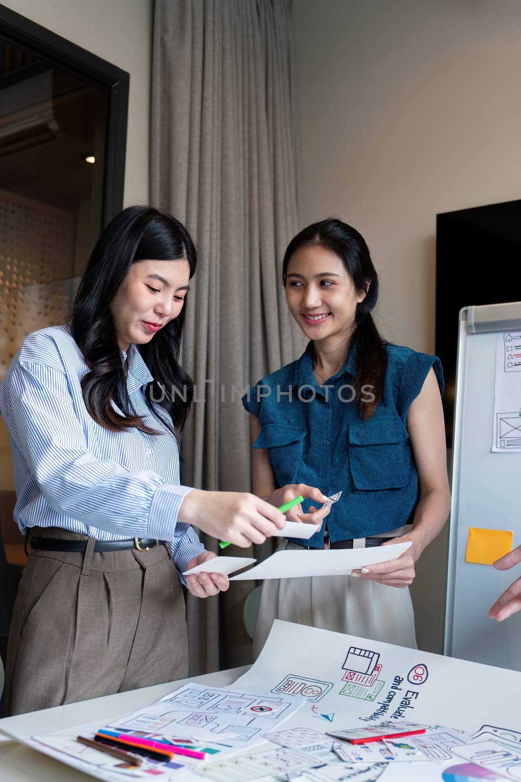 ux developer and ui designer presenting mobile app interface design on whiteboard in meeting at office. Creative digital development mobile app agency. digital transformation.