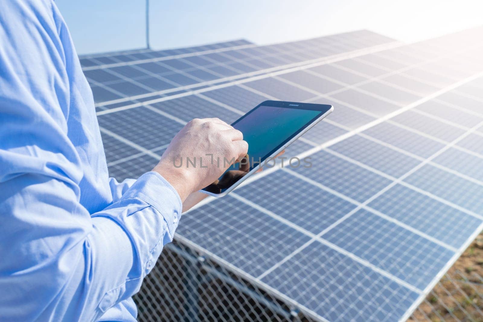 Close-up of a engineer checking solar panel setup. Using smart app in tablet by PaulCarr