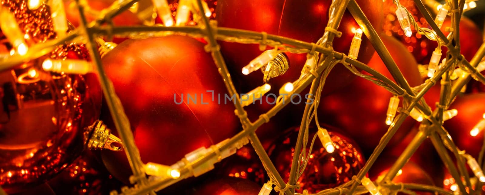 Red glowing Christmas balls garlands close-up. Holidays decoration and festive xmas concept. Copy space and empty place for text, mock up greeting card.