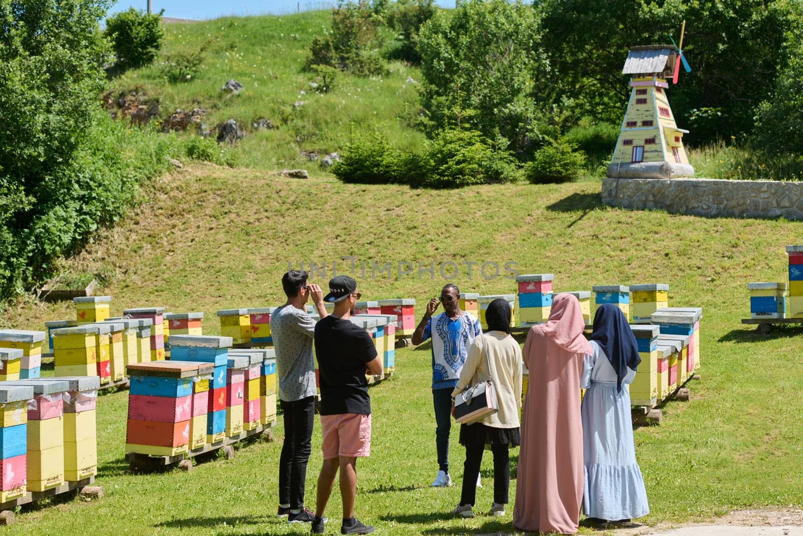 A diverse group of young friends and entrepreneurs explore small honey production businesses in the natural setting of the countryside. by dotshock