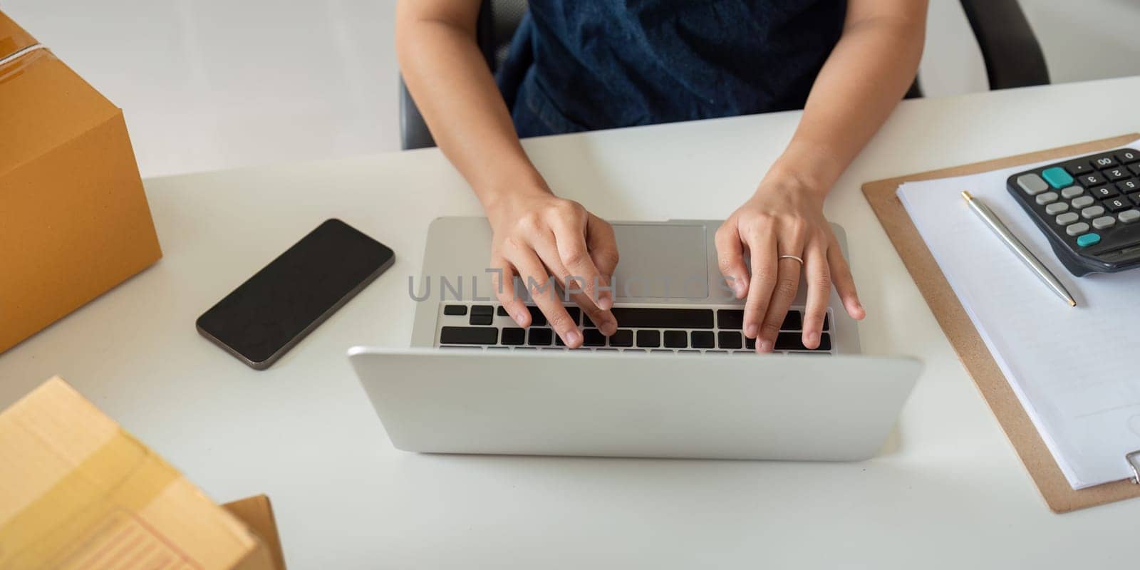 Woman in an online store check the customer address and package information on the laptop. Online shopping concept.