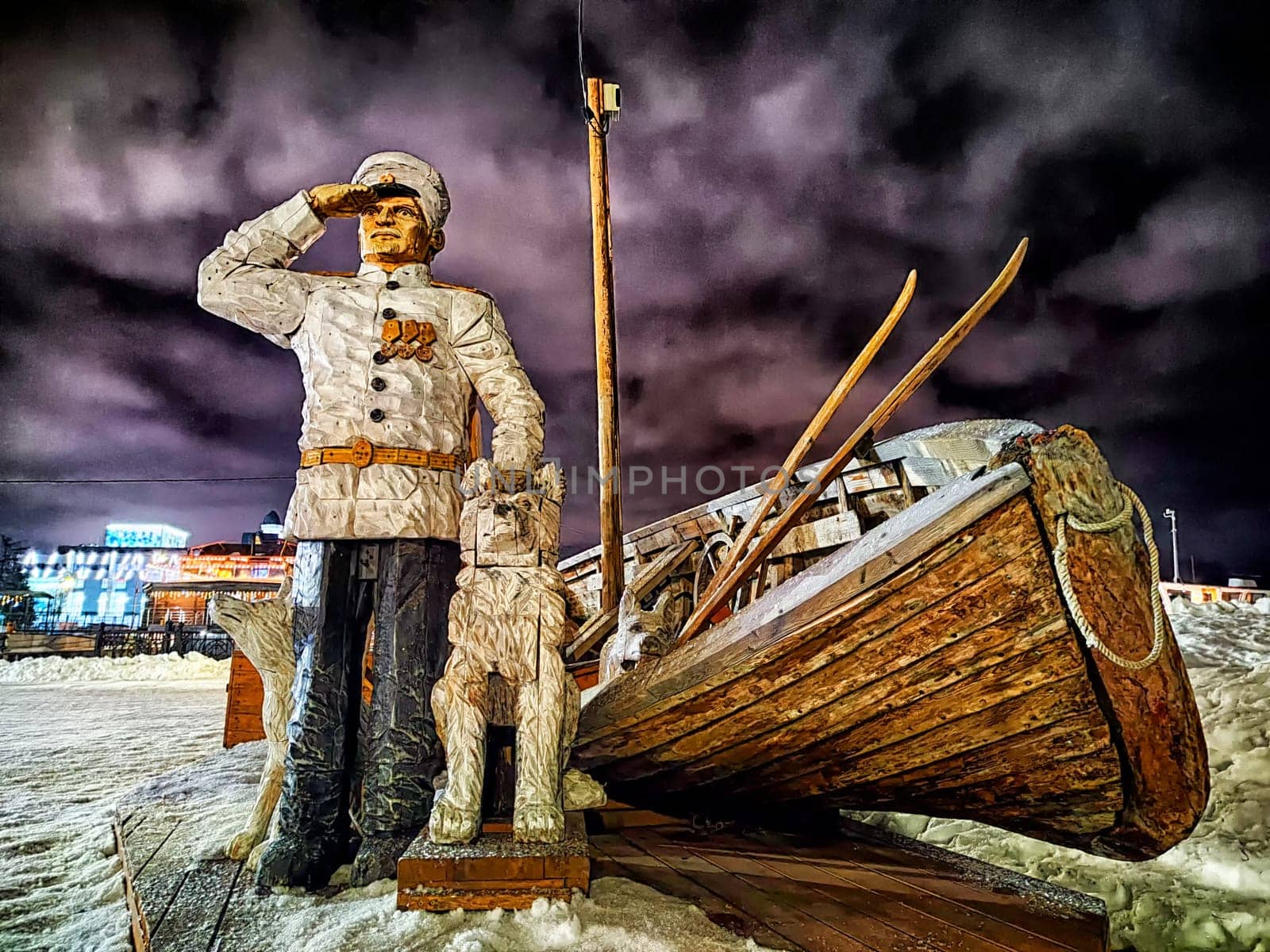 Arkhangelsk, Russia - February 28, 2024: Illuminated statue of historical figures by sled in Arkhangelsk. Conquerors of the North Monument in Arkhangelsk at Night