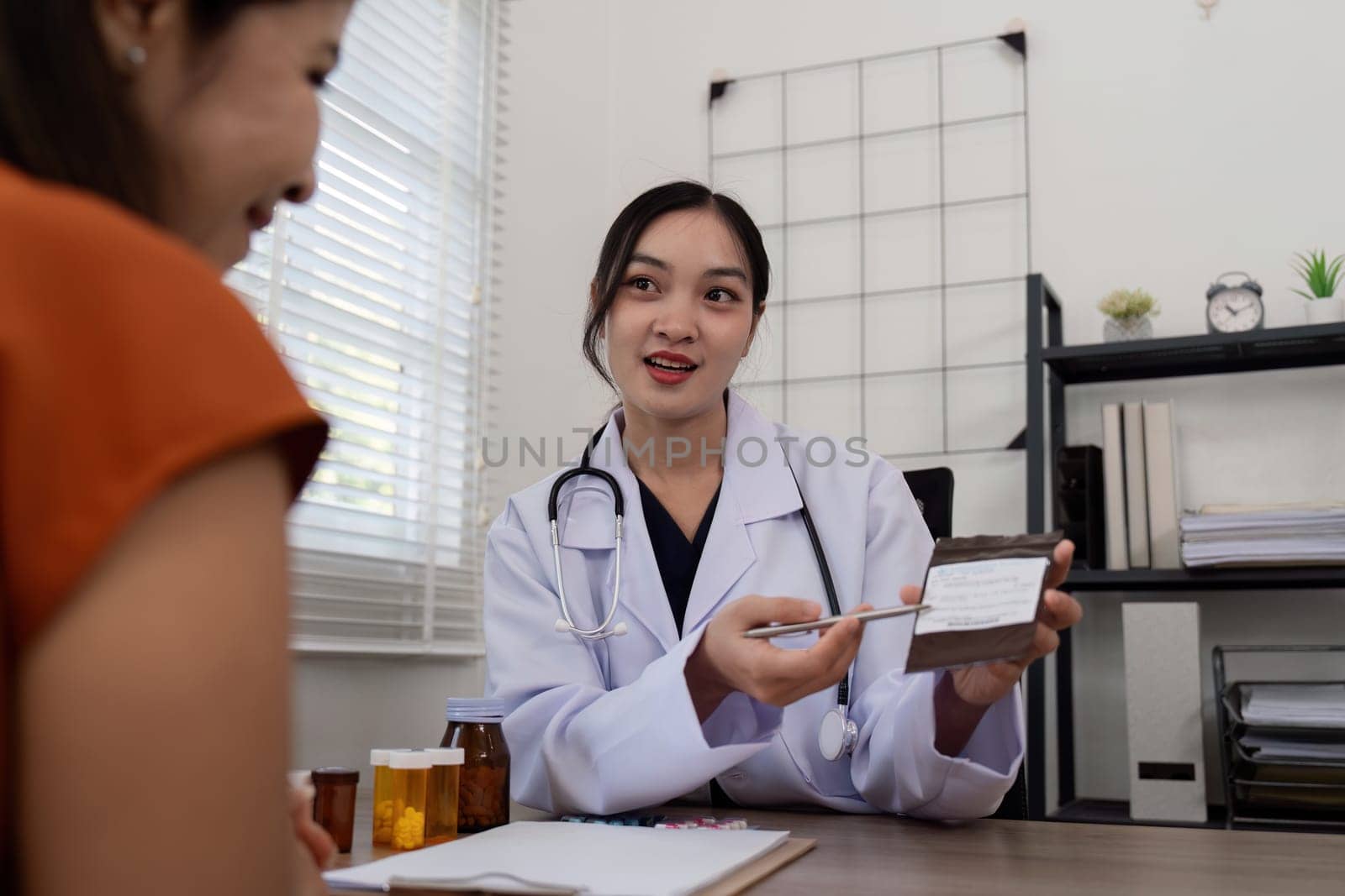 Doctor woman are recommend medicine to elderly woman patient after being examine by the patient doctor, the concept of treatment and symptomatic medication dispensing by the pharmacist by nateemee