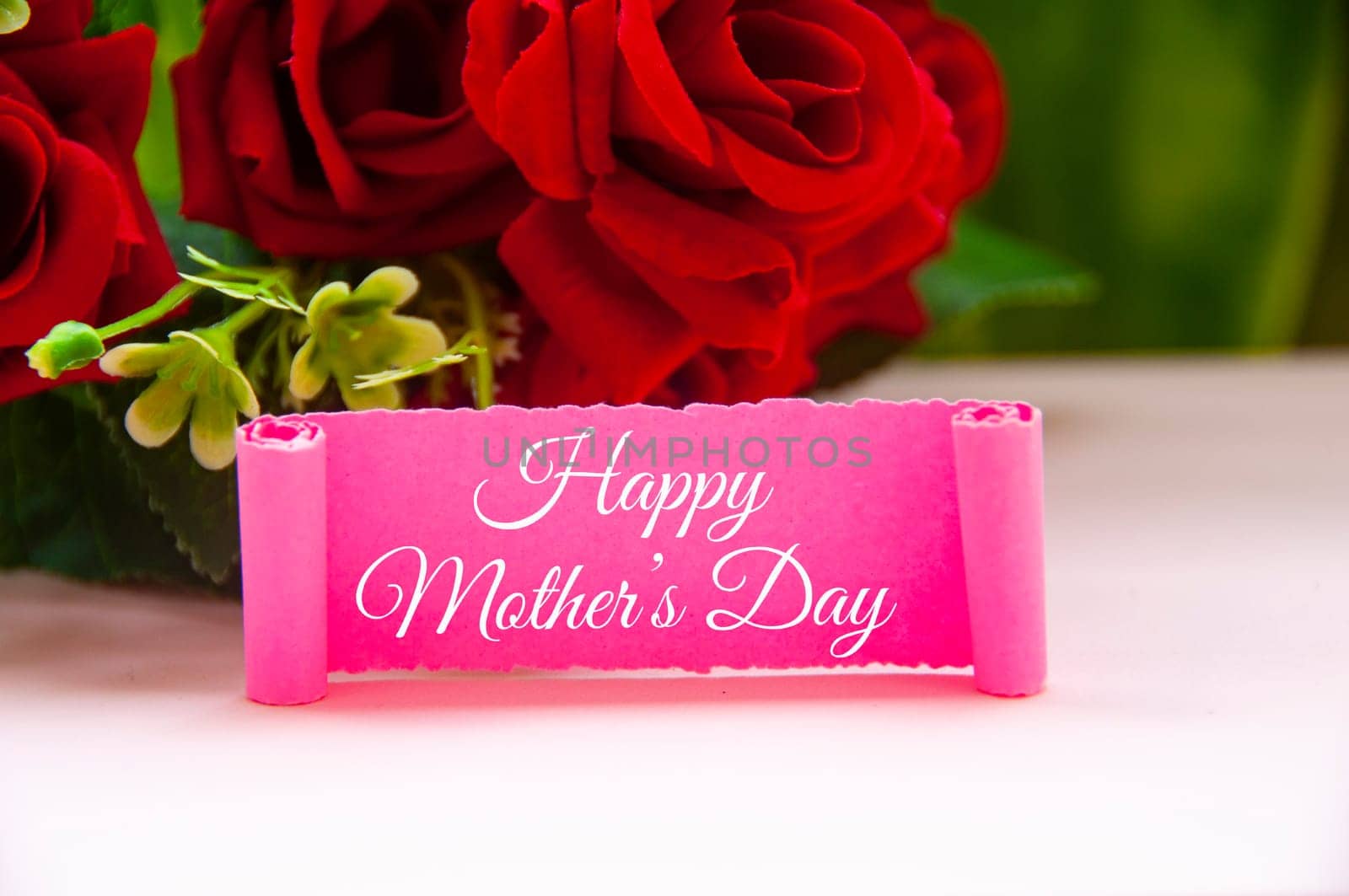 Happy mother's day text on pink paper with roses background.