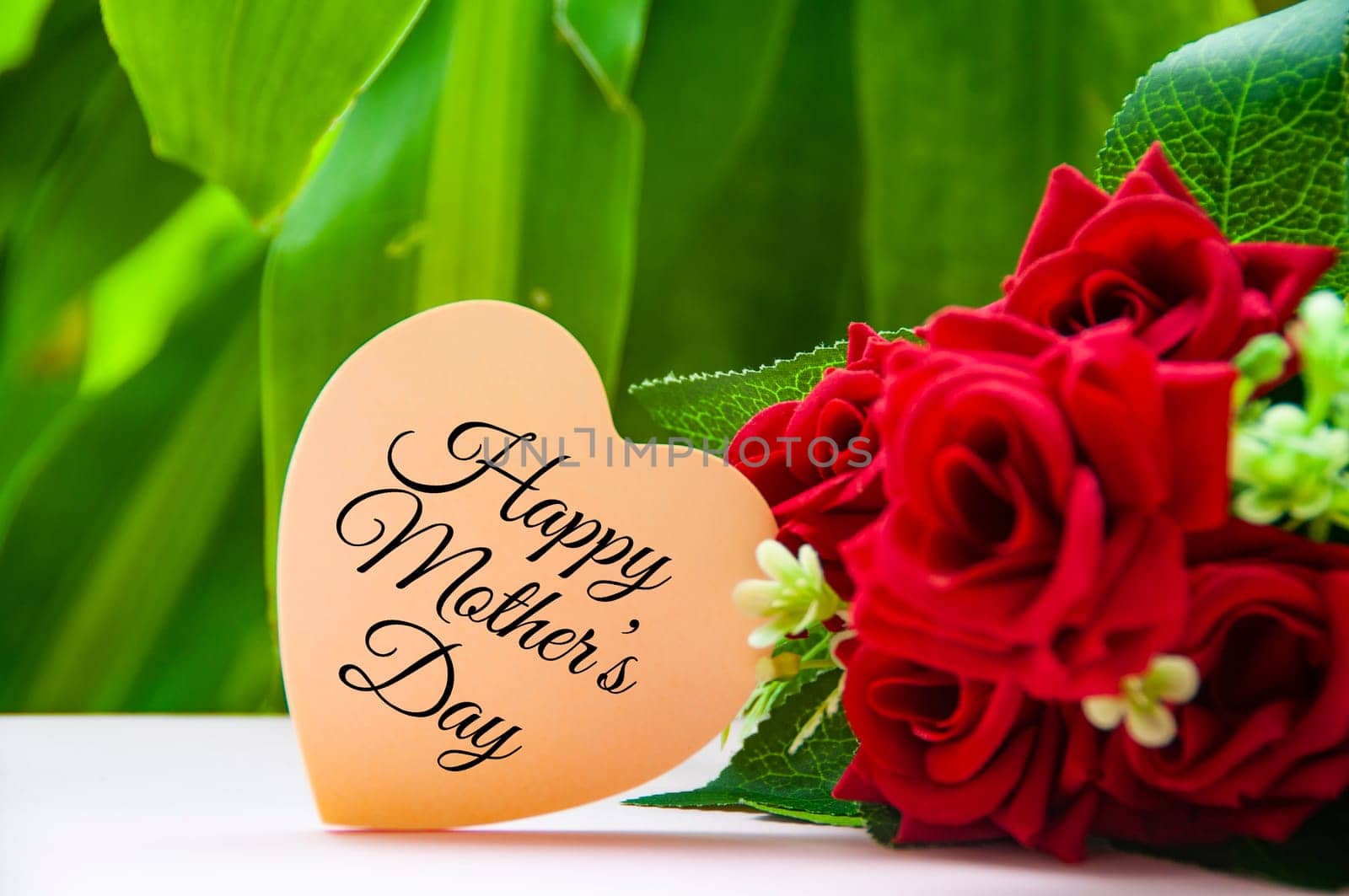 Happy mother's day text on light pink paper heart shape. Happy Mother's Day Concept.