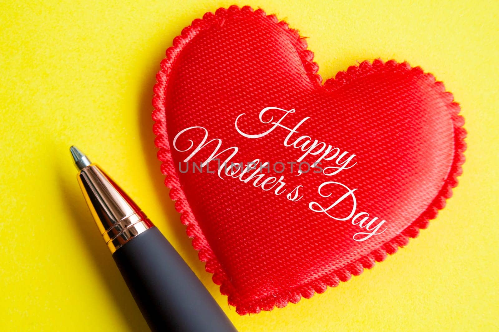 Top view of happy mother's day on red heart shape on yellow background. Happy Mother's Day Concept.