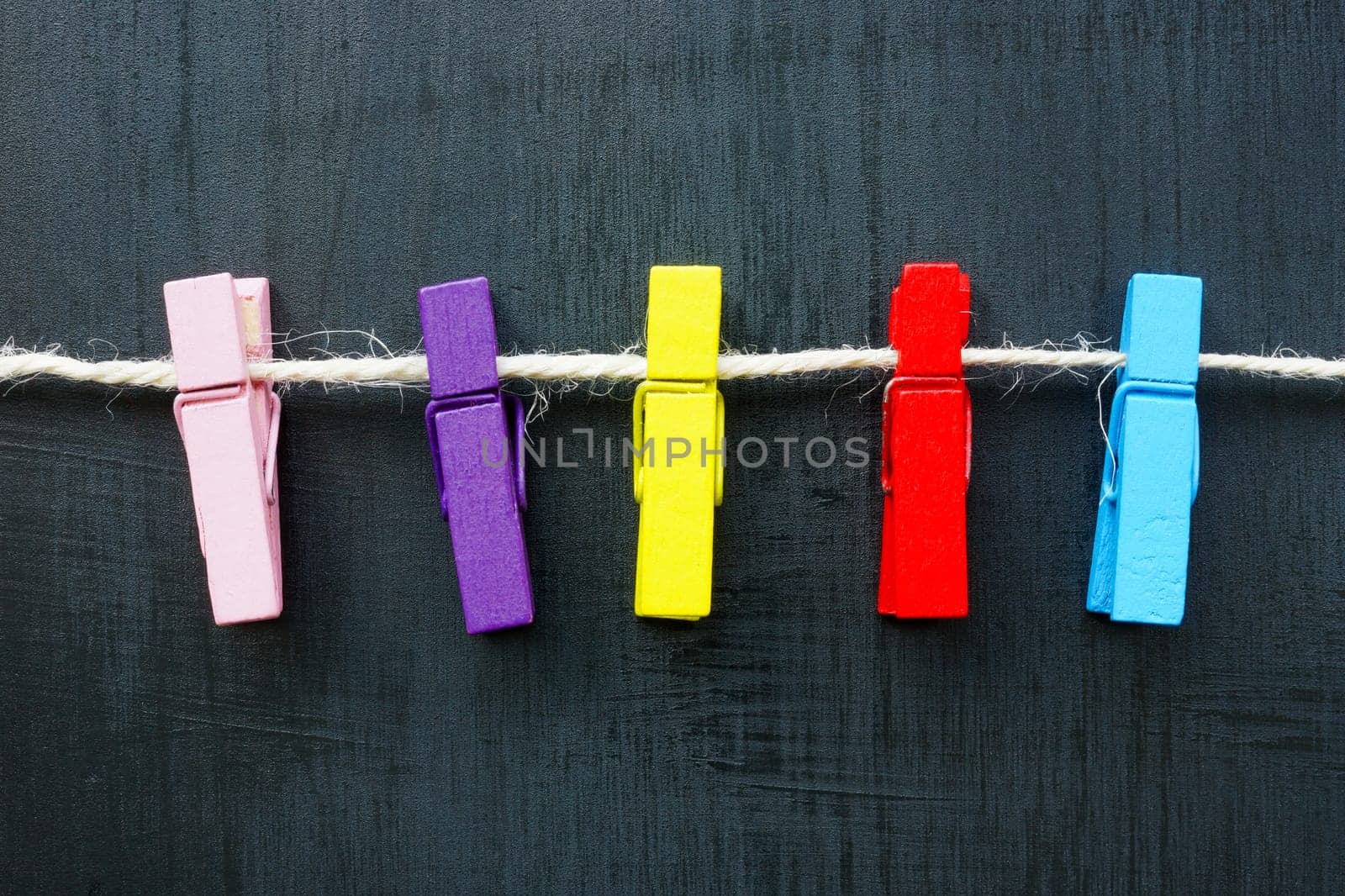 Multi-colored clothespins on a rope as concept for diversity.