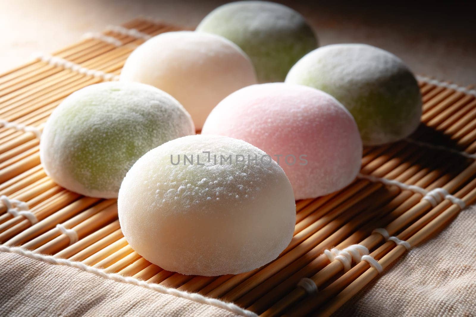 close-up of Japanese mochi on a bamboo mat. The mochi is soft, round, and gently dusted with a fine white powder.