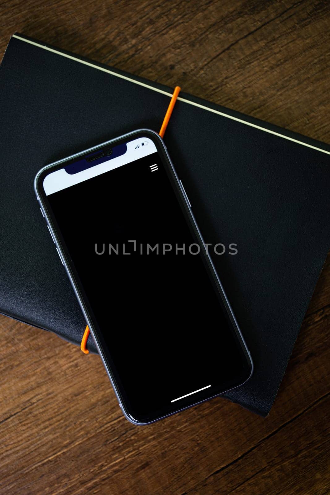 phone with notepad for your design on a wooden background.