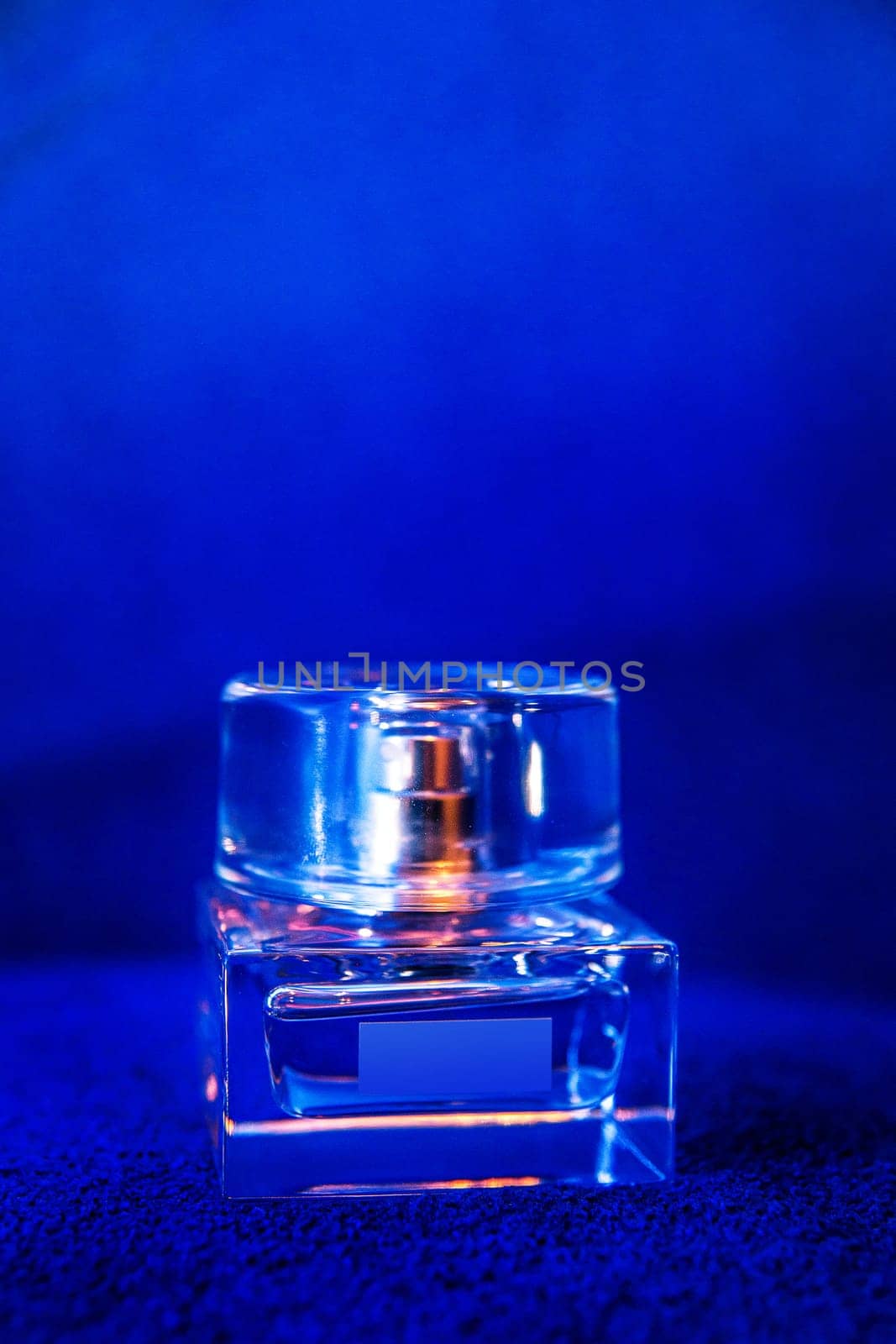 glass perfume bottle on a blue background.