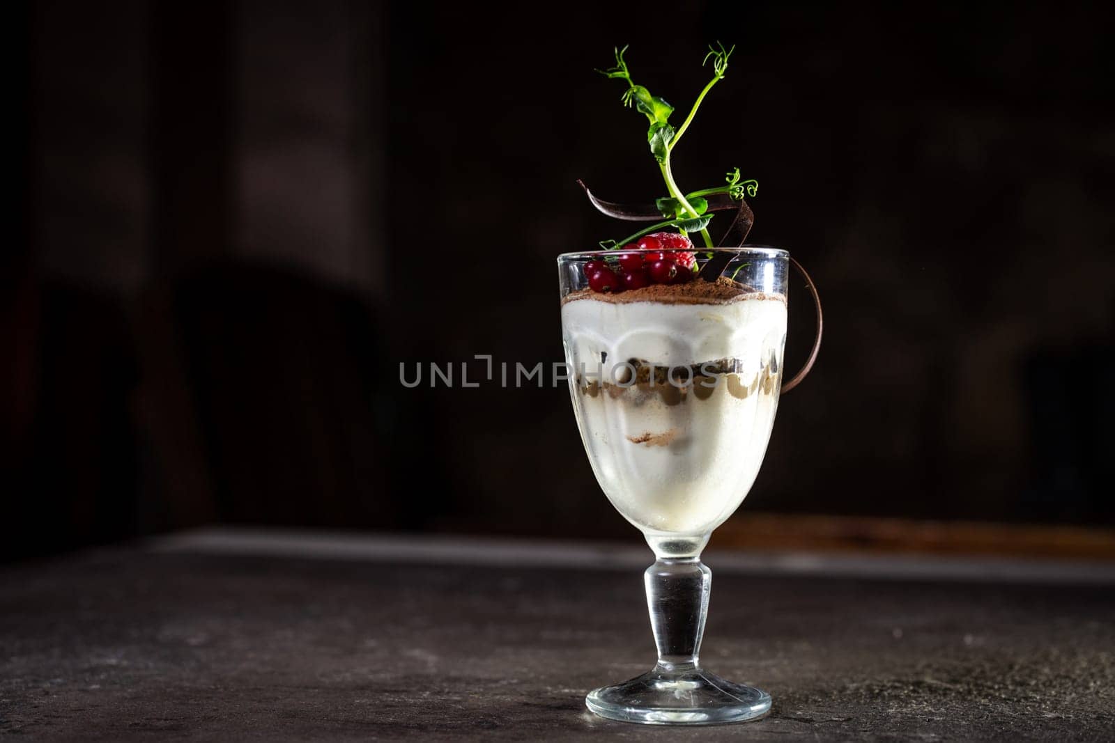 tiramisu dessert with berries in a glass on the table.