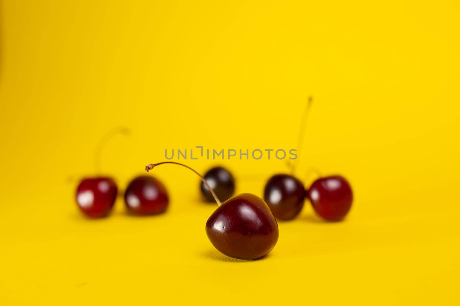 ripe cherries close-up on a yellow background.