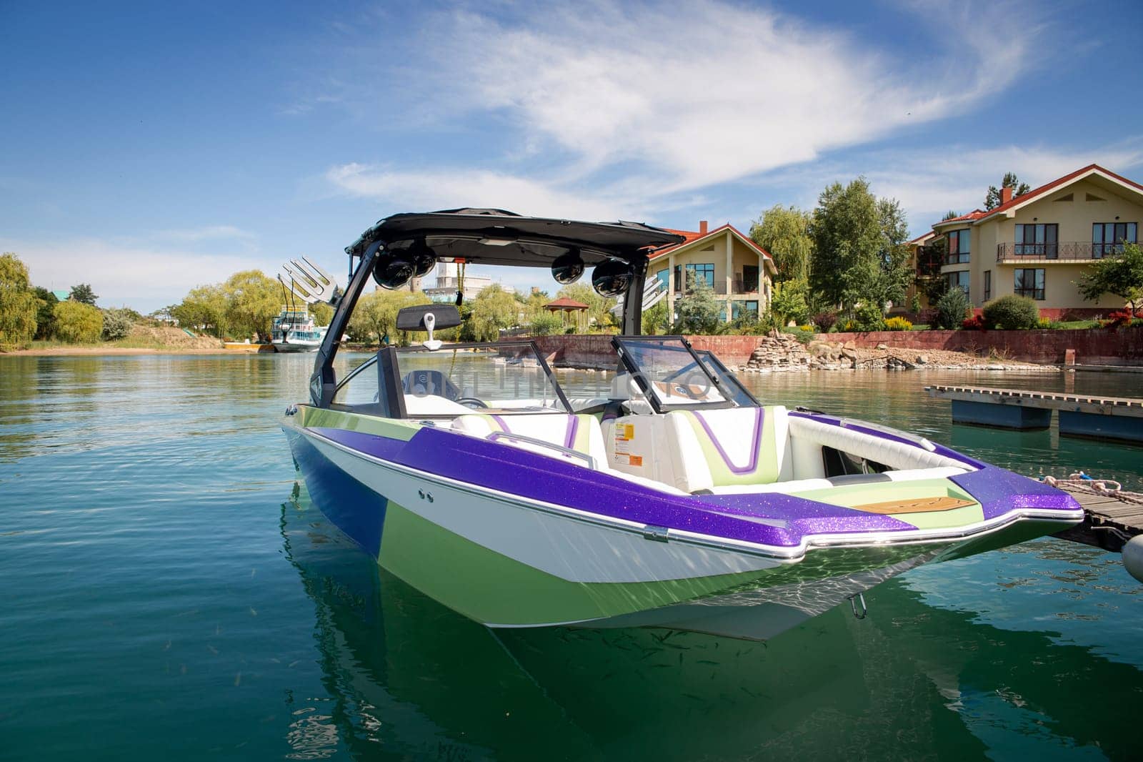 bright beautiful boat on the water near the recreation area in summer. by Pukhovskiy