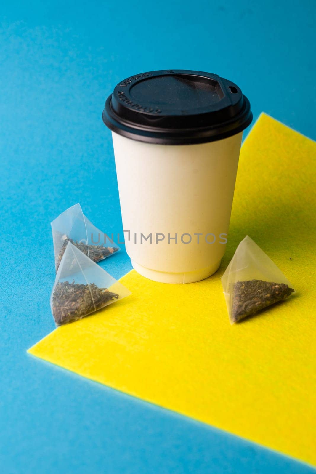 white paper cup and tea bags on the background.