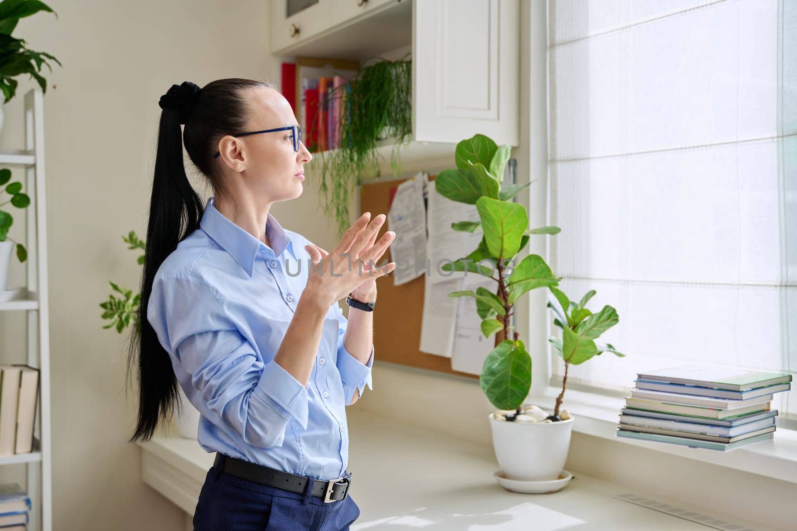 Serious thoughtful woman in her 30s looking out the window. Emotions, lifestyle, health, people concept