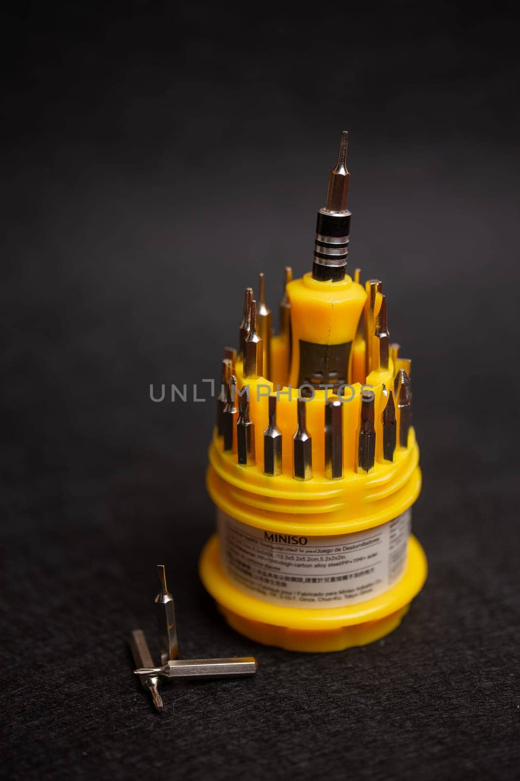 a set of yellow screwdrivers on a black background by Pukhovskiy