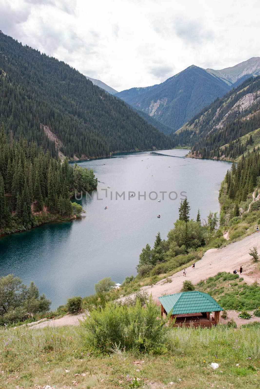 Scenic Lake with Snow-Capped Mountains and Small House on Shore by Pukhovskiy