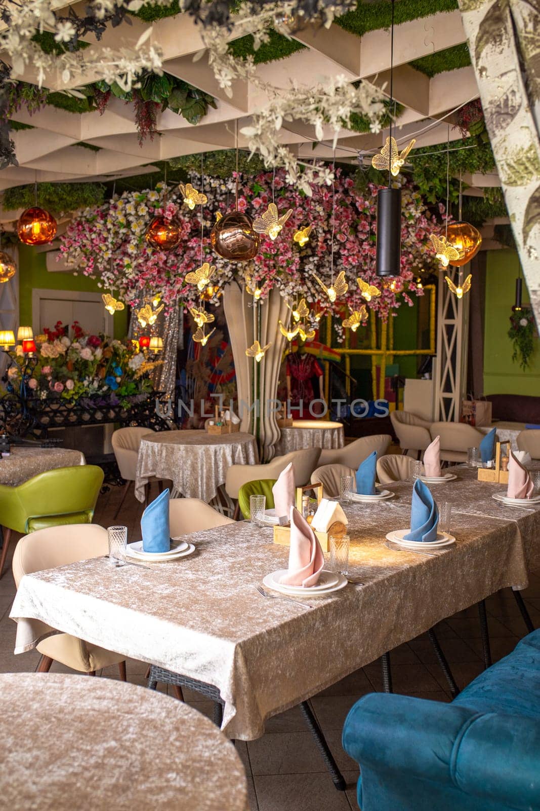 The image shows a beautifully decorated restaurant interior with a floral-adorned ceiling and elegant table settings.