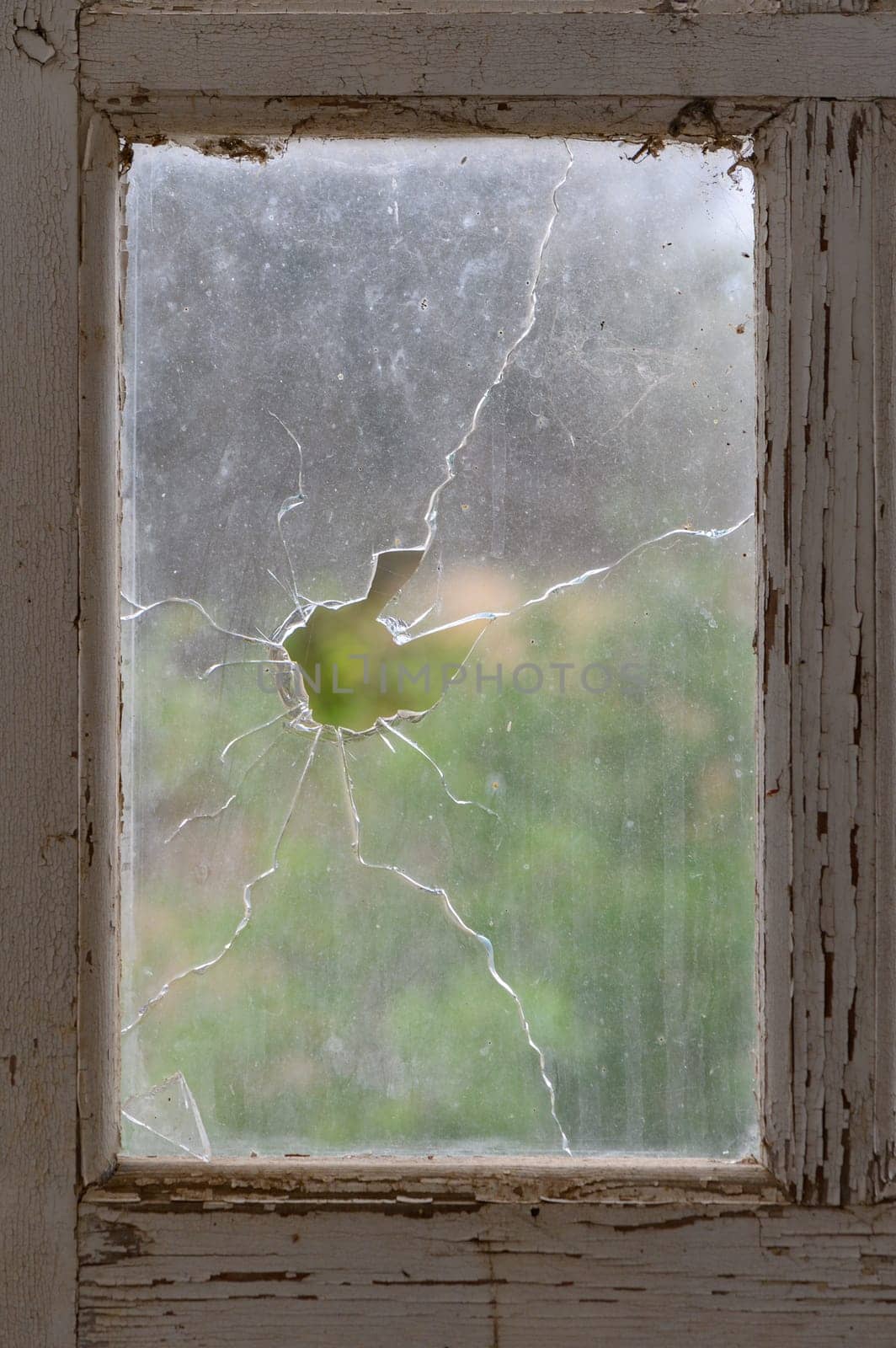 Window with broken glass in old building Wooden window frame with partially broken glass in old abandoned brick building 2