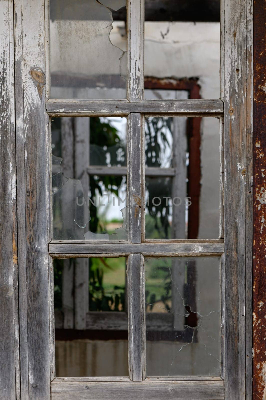 Window with broken glass in old building Wooden window frame with partially broken glass in old abandoned brick building by Mixa74