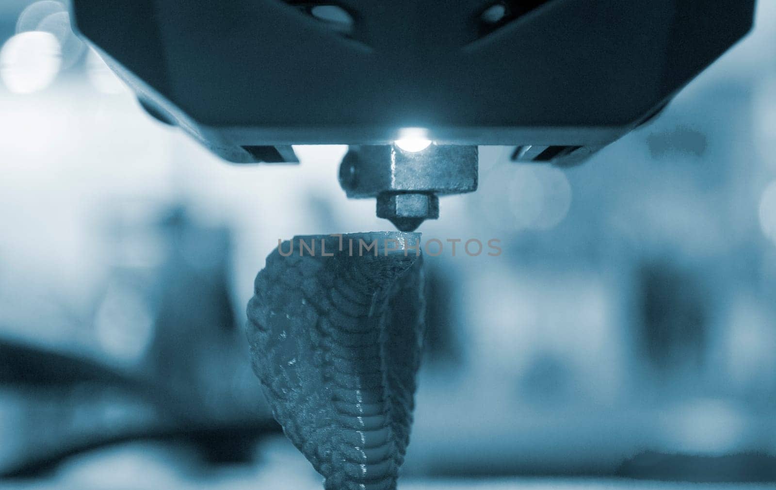 3D printer working close-up. 3D printer prints a model from molten yellow plastic close-up. 3D printer printing object. New modern prototyping technologies. Additive progressive high-tech technology.