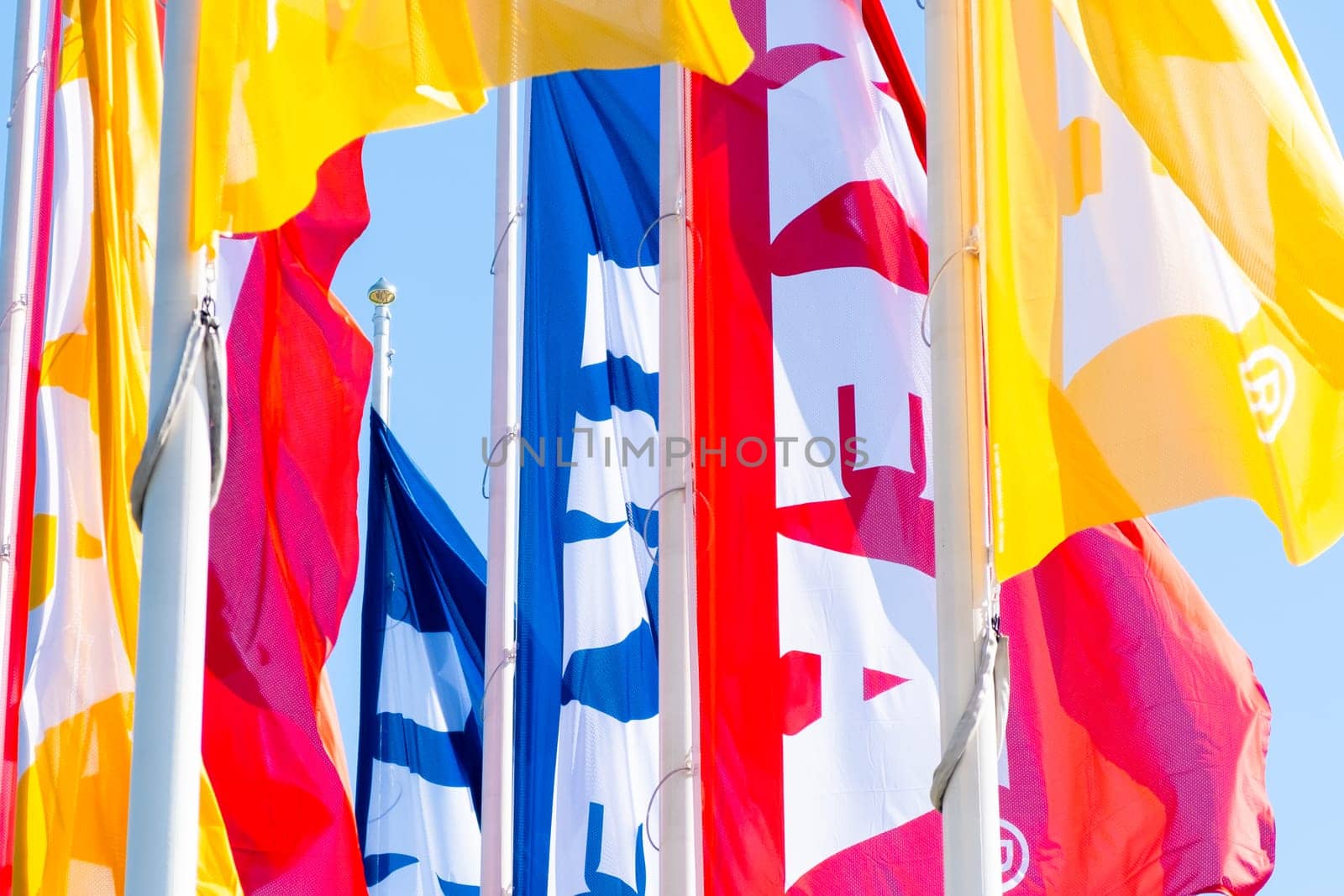 PRAGUE, CZECHIA -APRIL, 2024: Different colors IKEA mass market flags against blue sky.