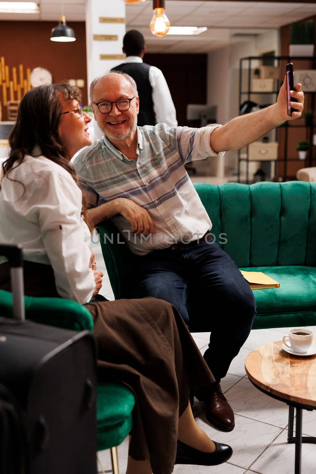 Couple taking selfies in elegant hotel by DCStudio