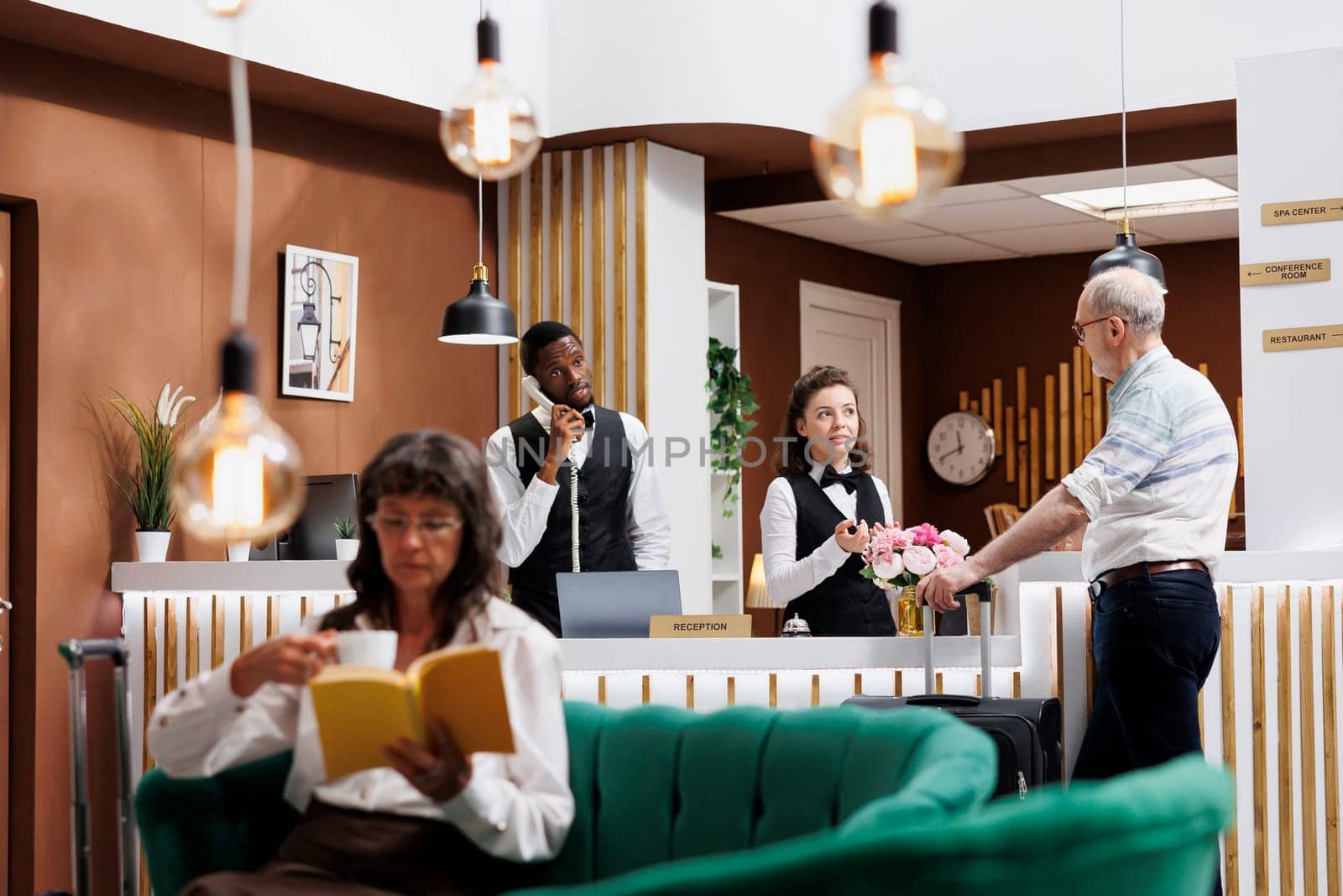 Friendly staff helps with hotel check-in by DCStudio