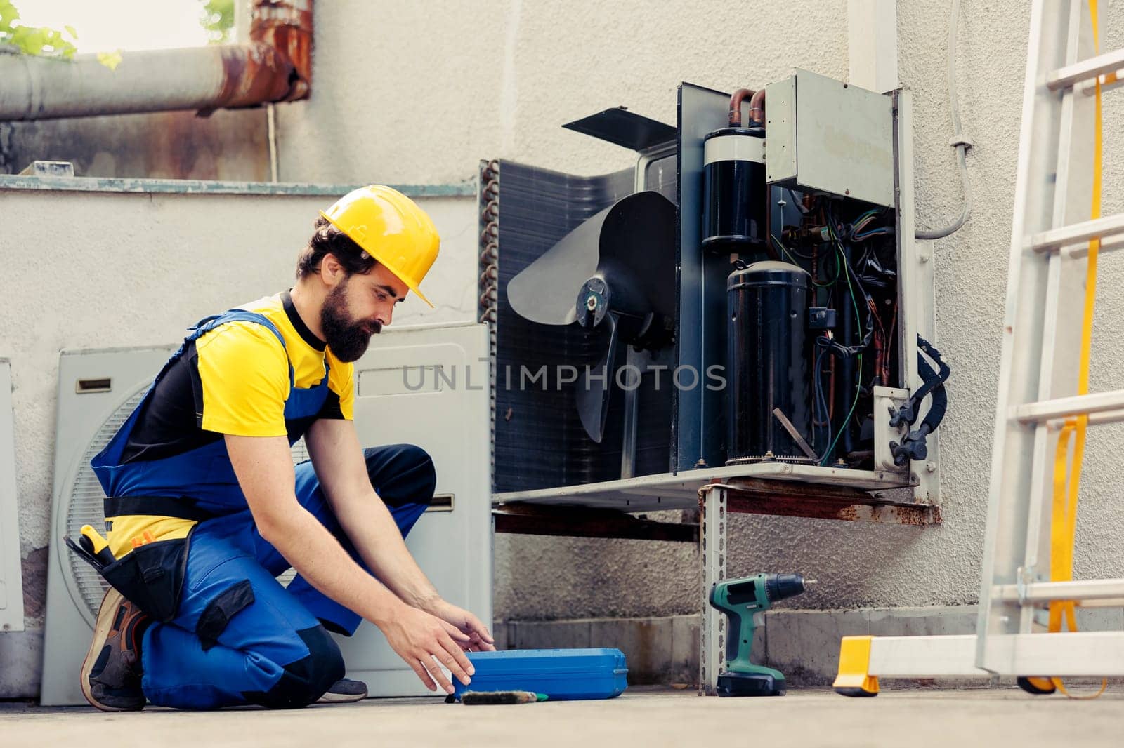 Wireman fixing broken air conditioner by DCStudio