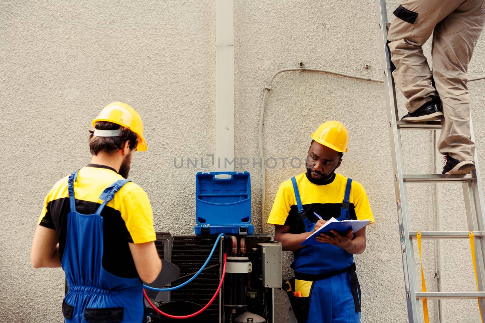 Proficient expert using professional pressure benchmarking tools to check liquids and gases in hvac system while licensed electrician writes condenser analysis report on clipboard