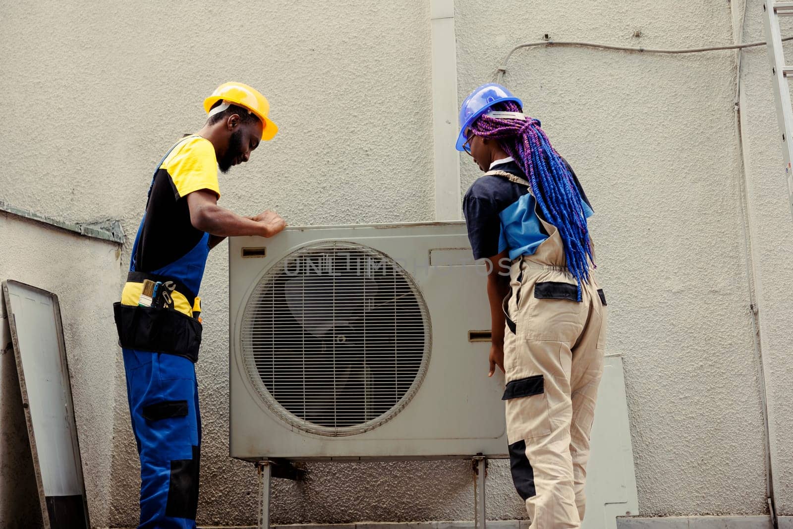 Engineers dismantling hvac system panel by DCStudio