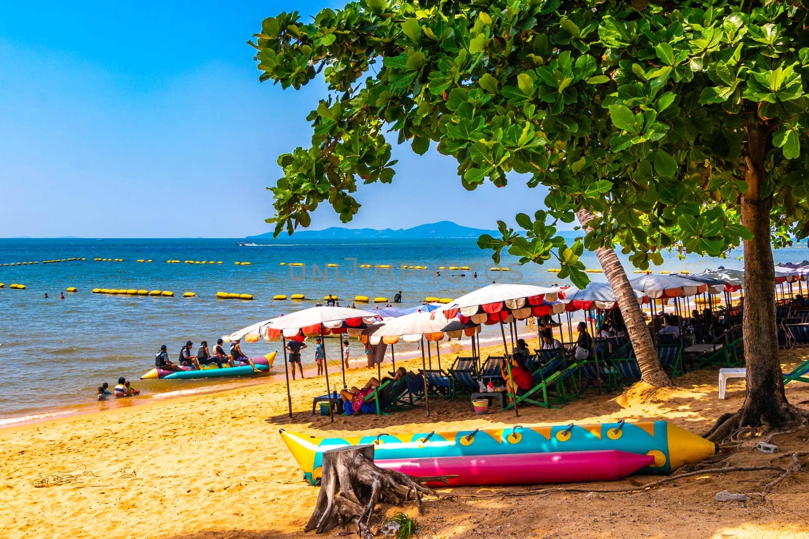 Tropical beach waves sand people boat palm trees Pattaya Thailand. by Arkadij