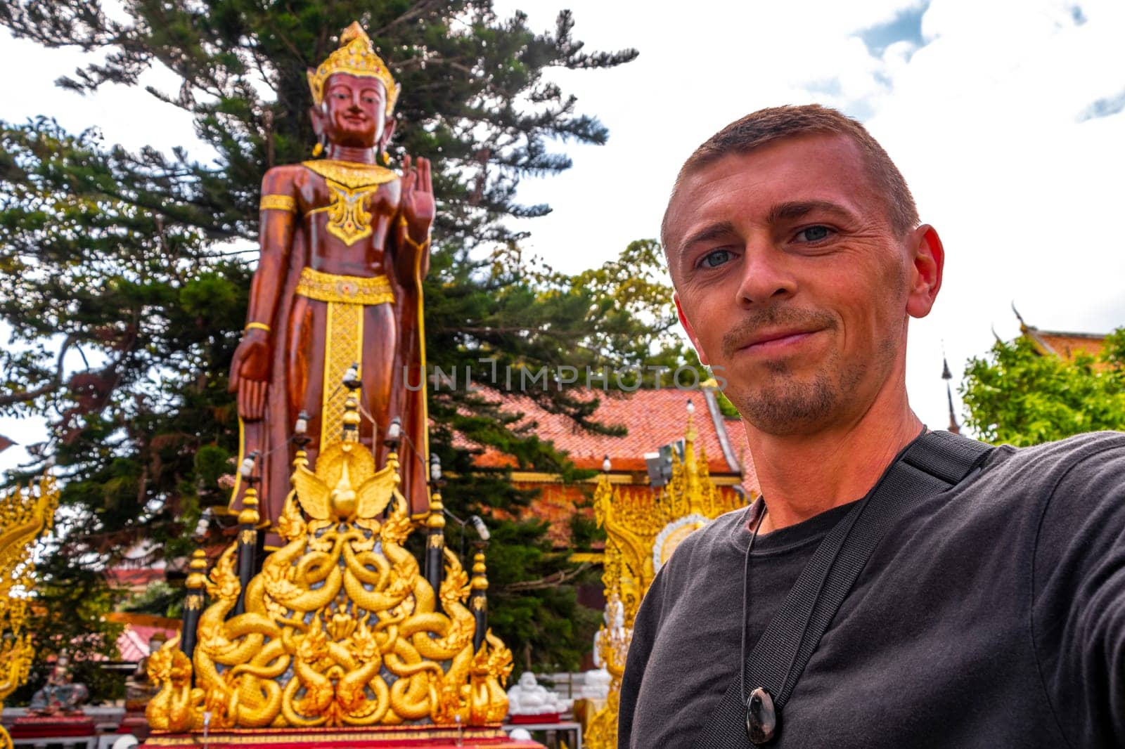 Handsome man male tourist at golden gold Wat Phra That Doi Suthep temple temples building in Chiang Mai Amphoe Mueang Chiang Mai Thailand in Southeastasia Asia.