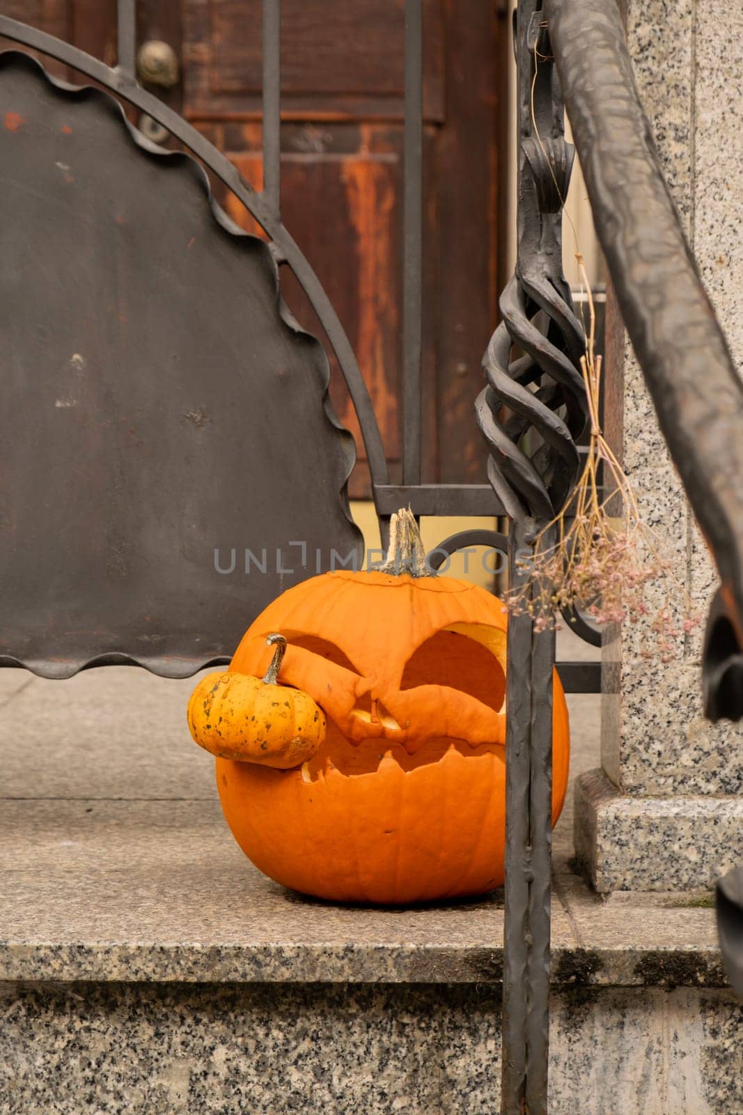 Halloween decorated outdoor cafe or restaurant terrace in America or Europe with carved pumpkins traditional attributes of Halloween. Frontyard decoration by anna_stasiia