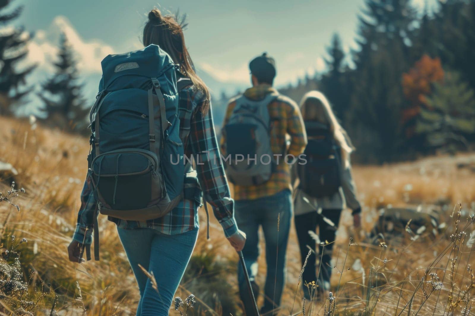 A group of people are walking through a field with backpacks and one of them is holding a baseball bat