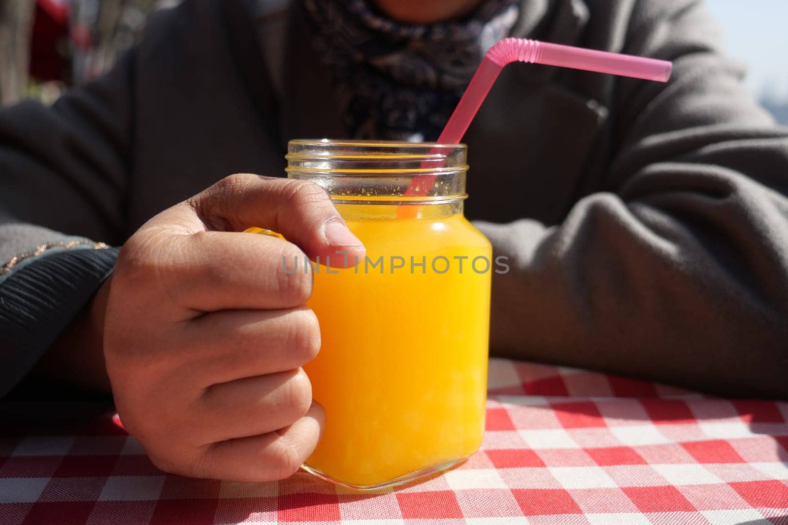 women hand holding a glass of orange juice.